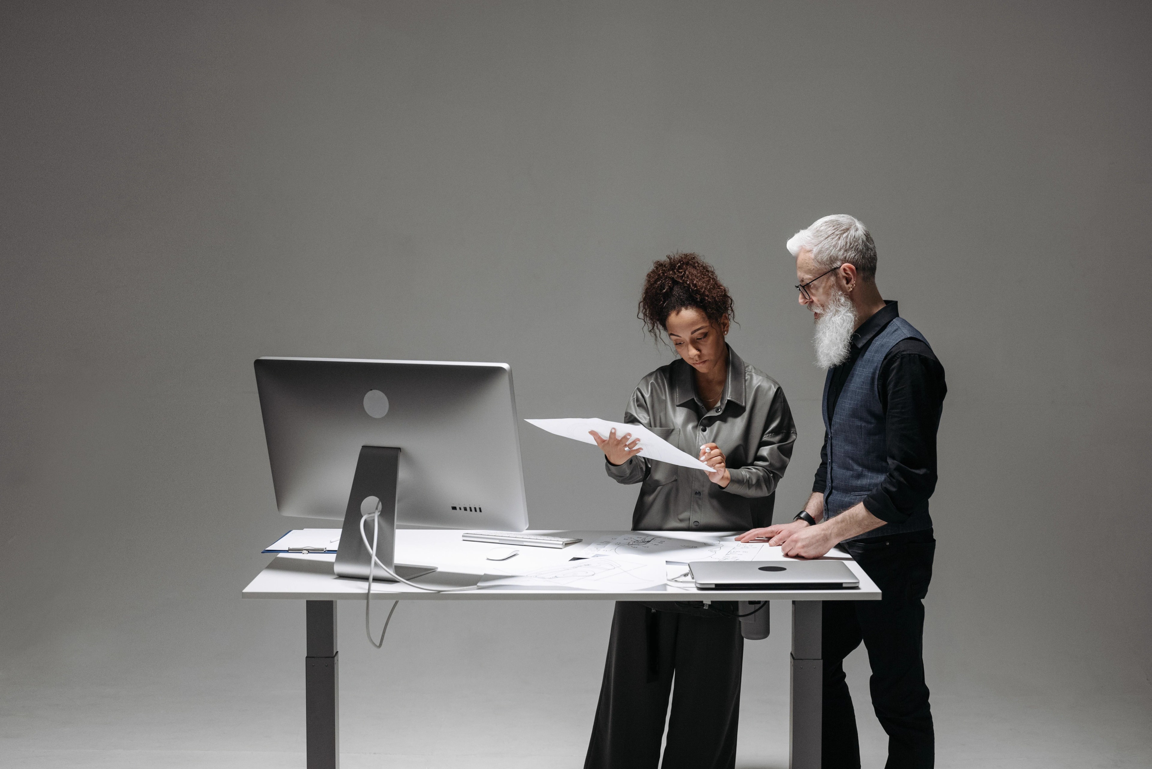 Zwei Fachkräfte gleichen Unterlagen an einem digitalen Arbeitsplatz ab