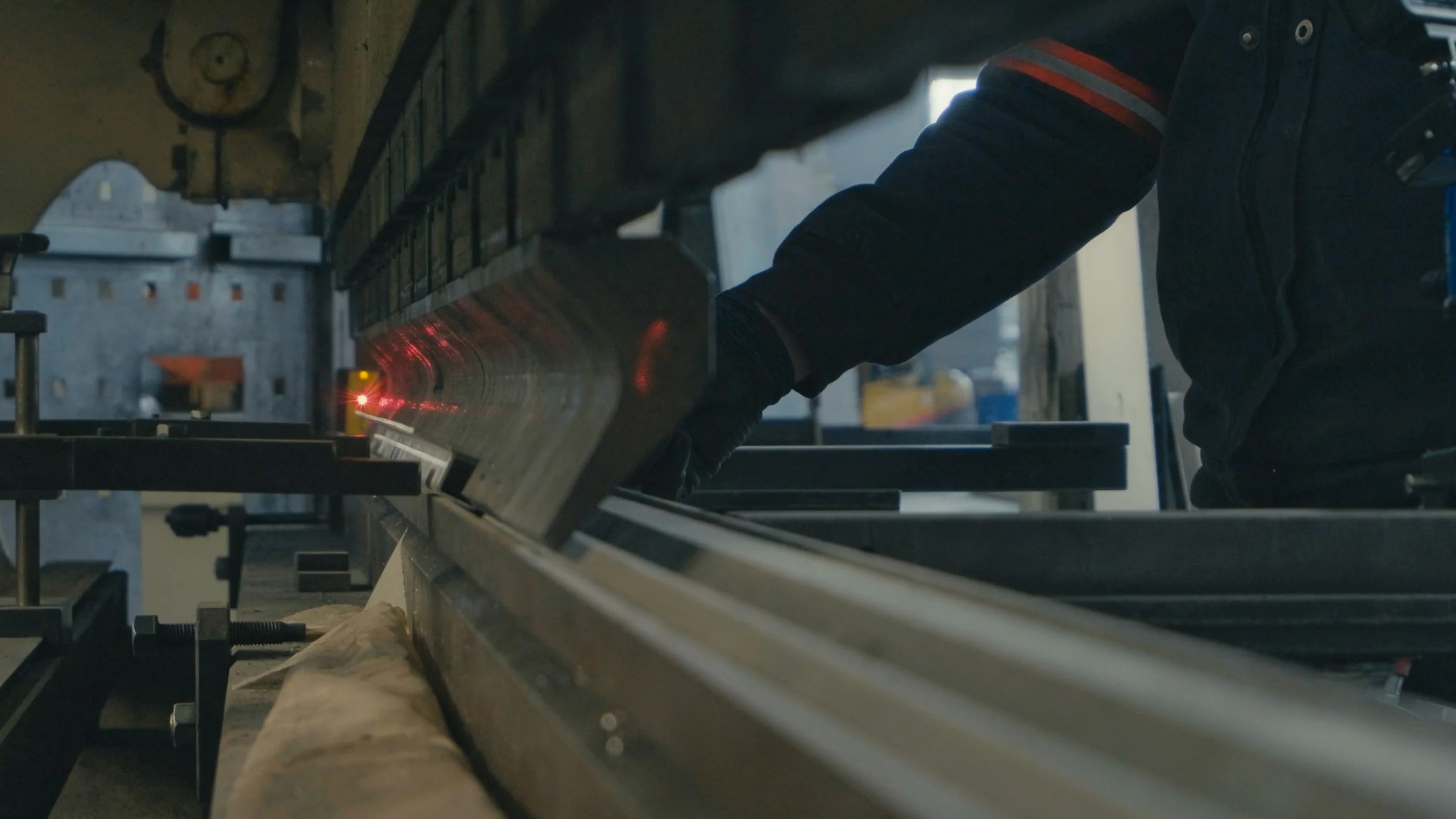 Mitarbeiter beim präzisen Biegen eines Metallteils an einer industriellen Maschine